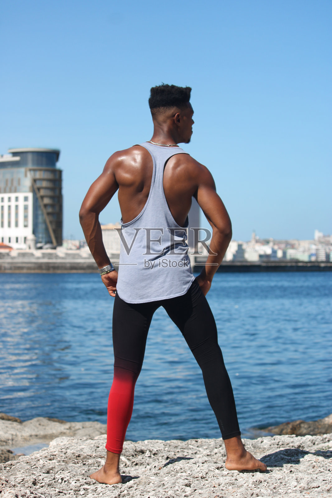 一名年轻的非裔美国人在哈瓦那湾的海边进行练习。这个年轻人肌肉发达，相貌英俊。照片摄影图片