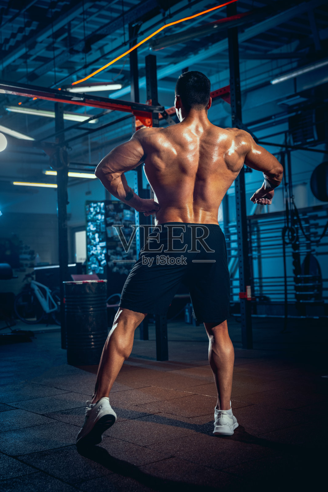 年轻男子的肖像，肌肉运动员，健美运动员在体育馆里摆姿势，室内。运动的概念，活动，健康的生活方式照片摄影图片