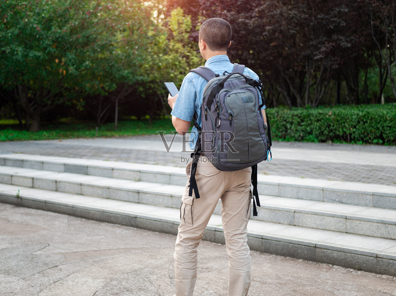背包客用手机搜索信息照片摄影图片