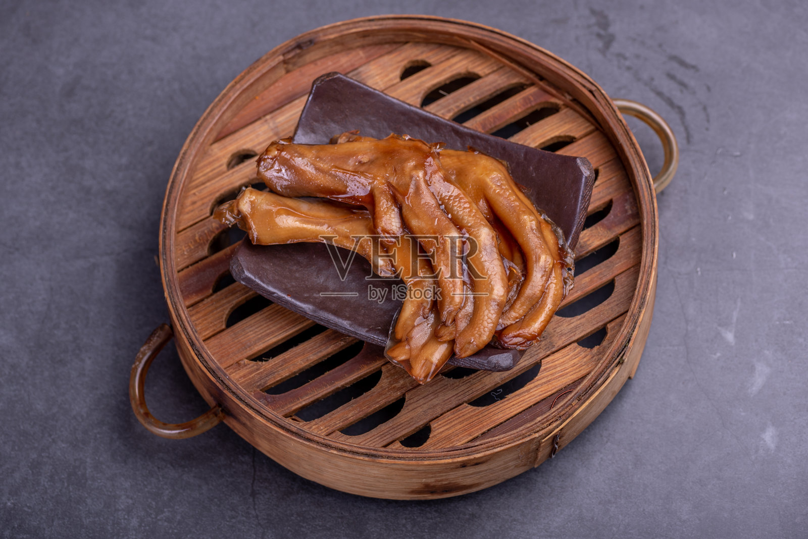 容器里的炖鸭爪以黑色为背景照片摄影图片