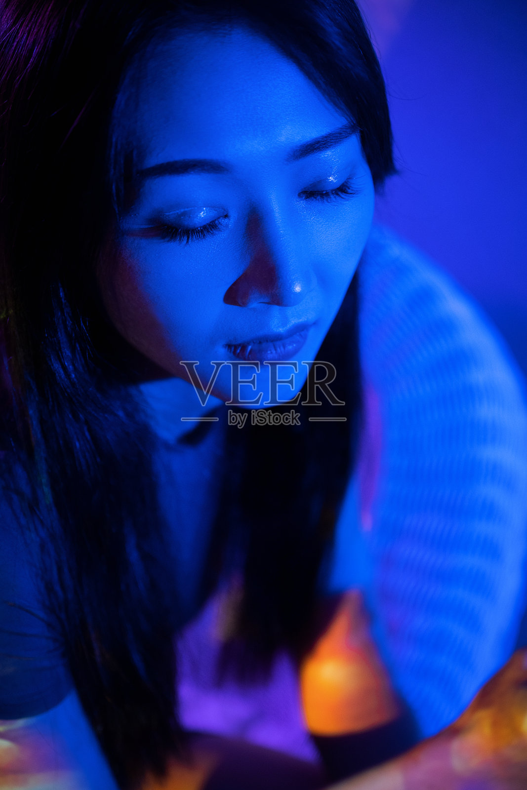 那个穿灰色衣服的漂亮女人手里拿着一朵玫瑰照片摄影图片