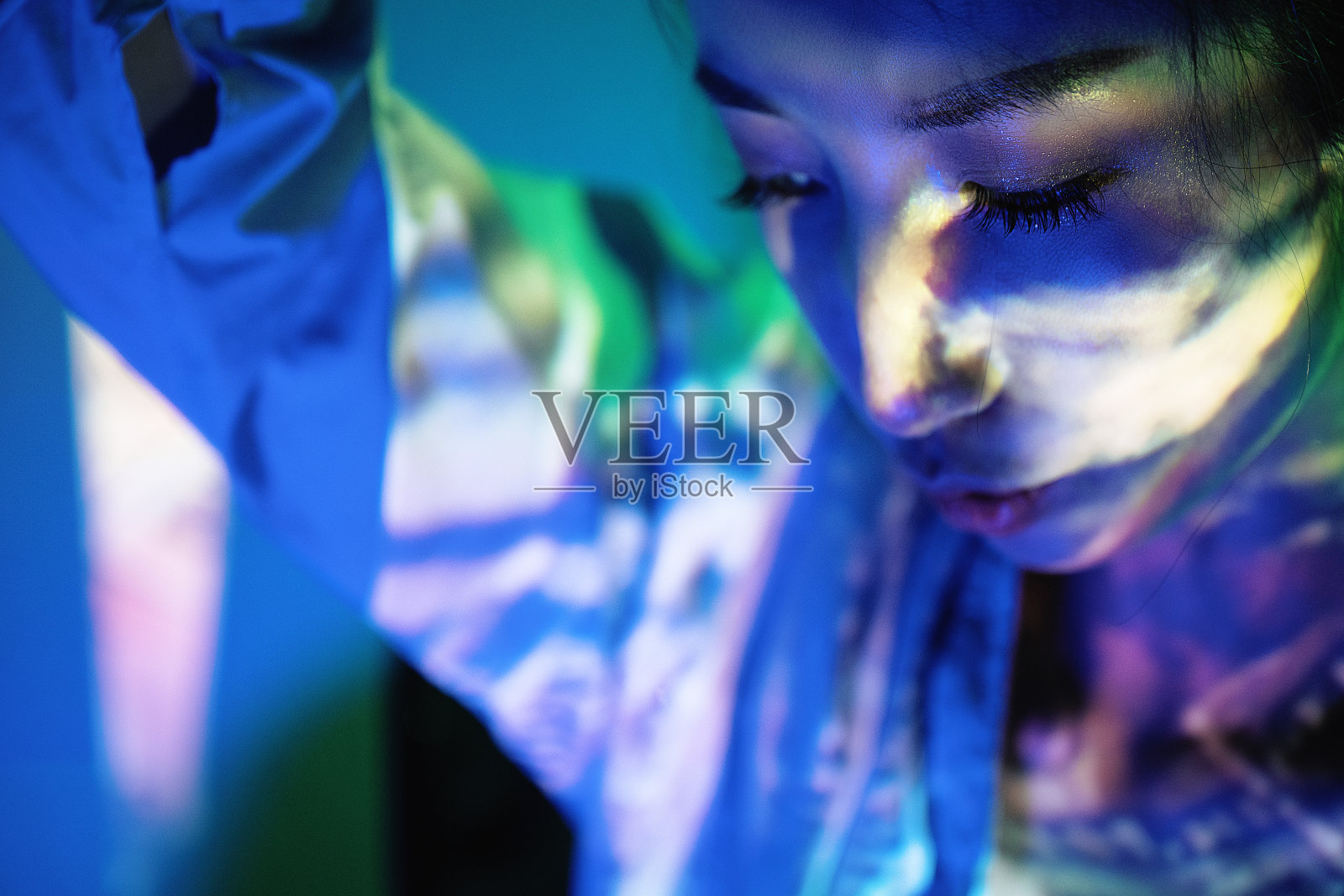 霓虹灯照在拿着透明眼镜的美女身上照片摄影图片