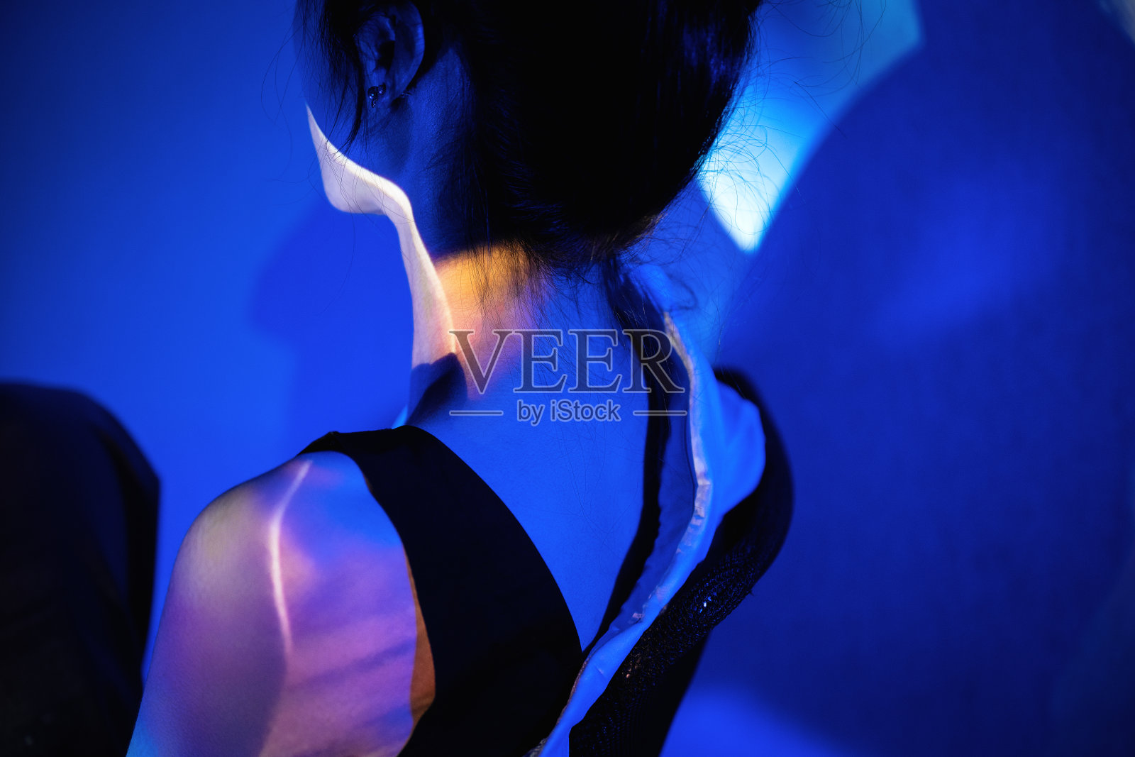 霓虹灯照亮了穿着黑色吊带的美女照片摄影图片