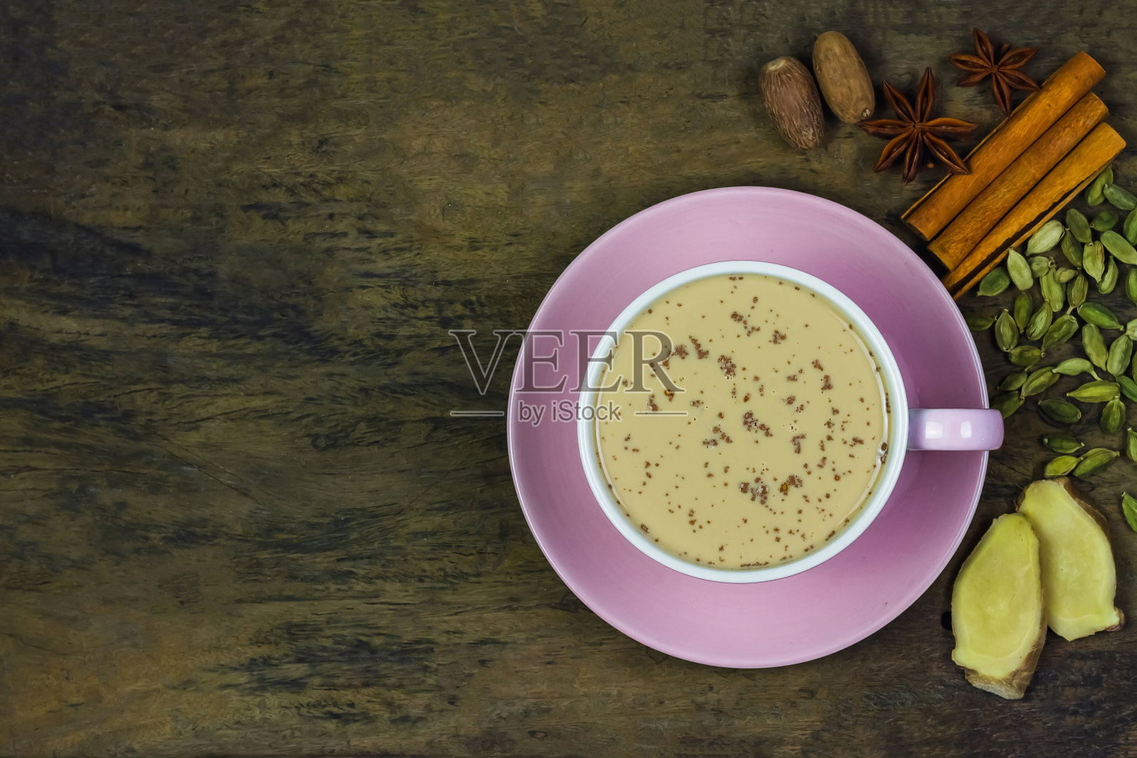 一杯马萨拉chai茶与姜，小豆蔻，肉桂，肉豆蔻，和茴芹在乡村木制背景俯视图。照片摄影图片