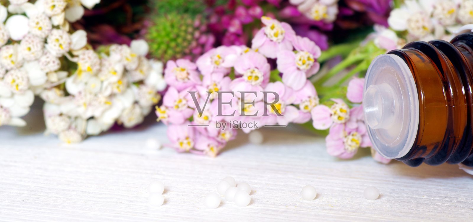 带有白色和玫瑰色花朵的顺势疗法小球照片摄影图片