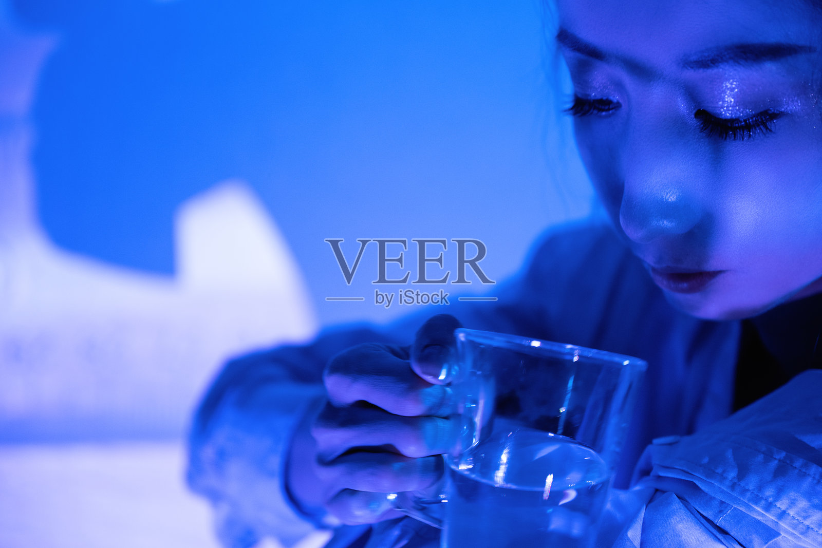 霓虹灯照在拿着透明眼镜的美女身上照片摄影图片