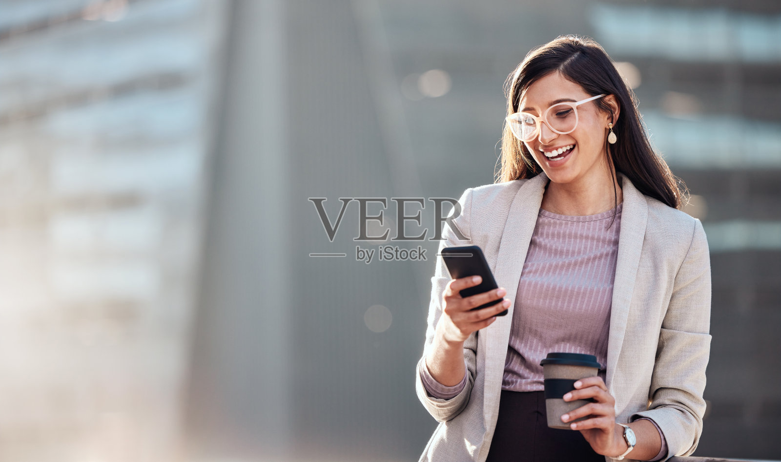 一个漂亮的年轻女商人独自站在外面用手机照片摄影图片