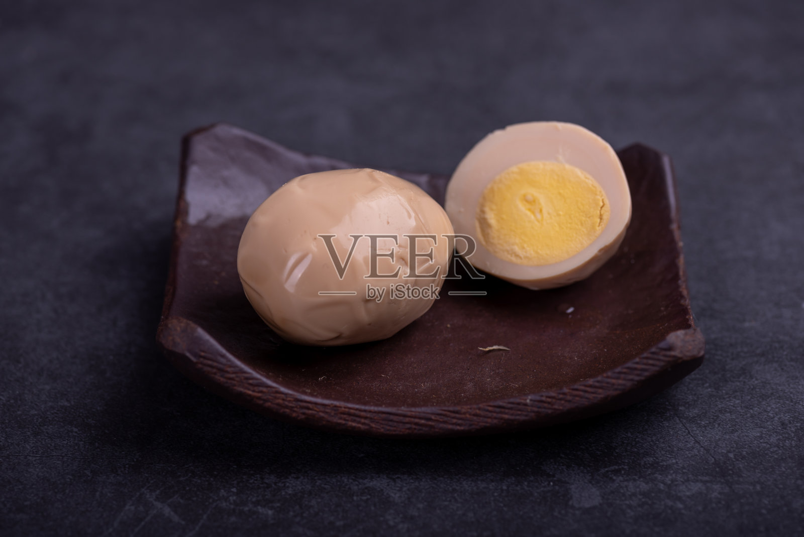 中国茶叶蛋，黑色背景下，切好的或整个腌制的鸡蛋照片摄影图片