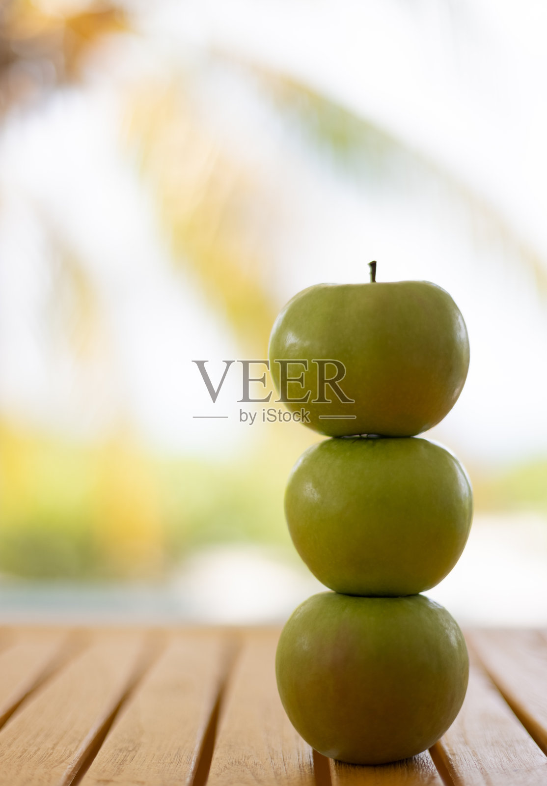 三个苹果钉在棕榈树上。特写镜头。选择性聚焦，背景模糊。照片摄影图片