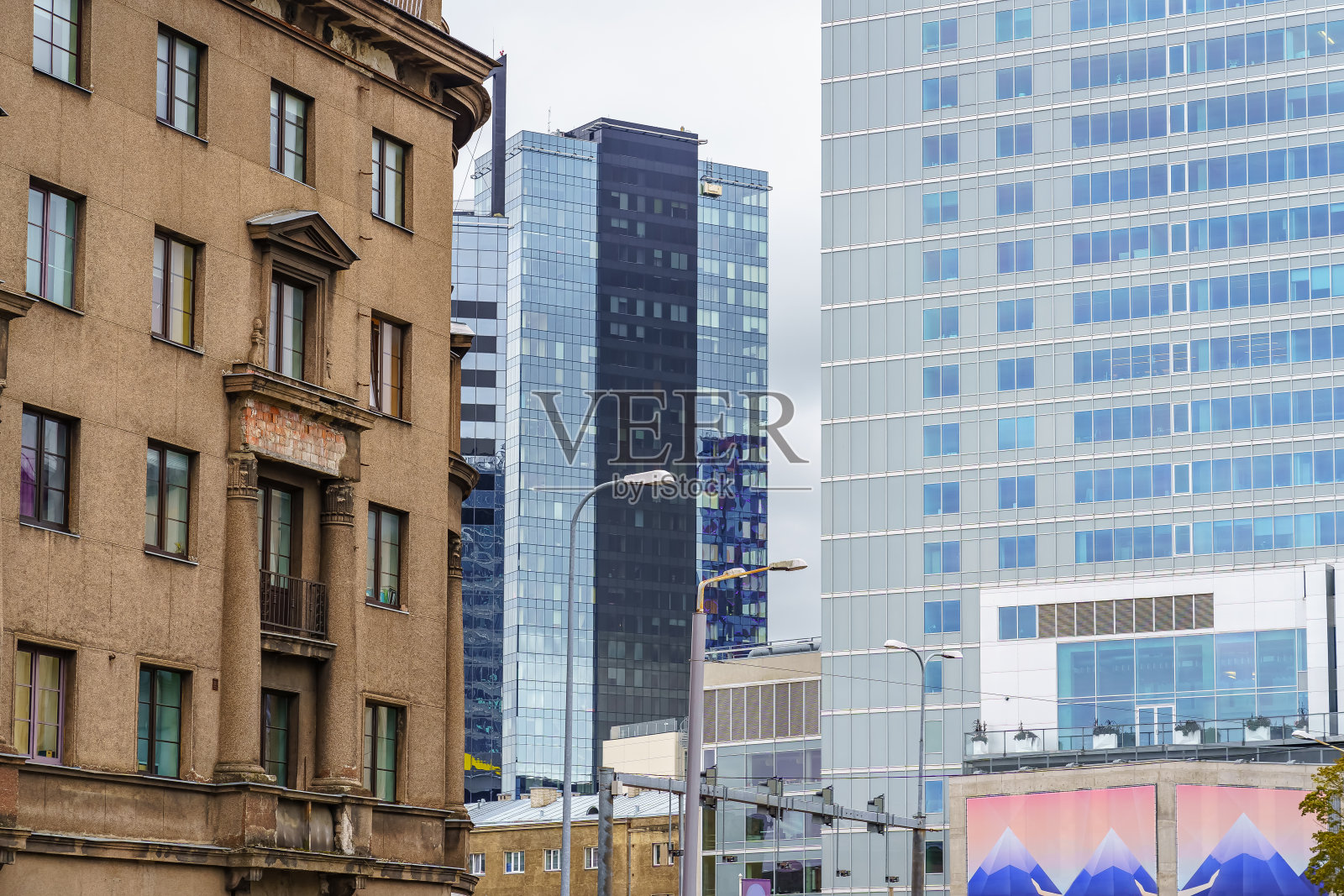 在爱沙尼亚塔林市中心，现代玻璃建筑紧挨着旧砖建筑。照片摄影图片