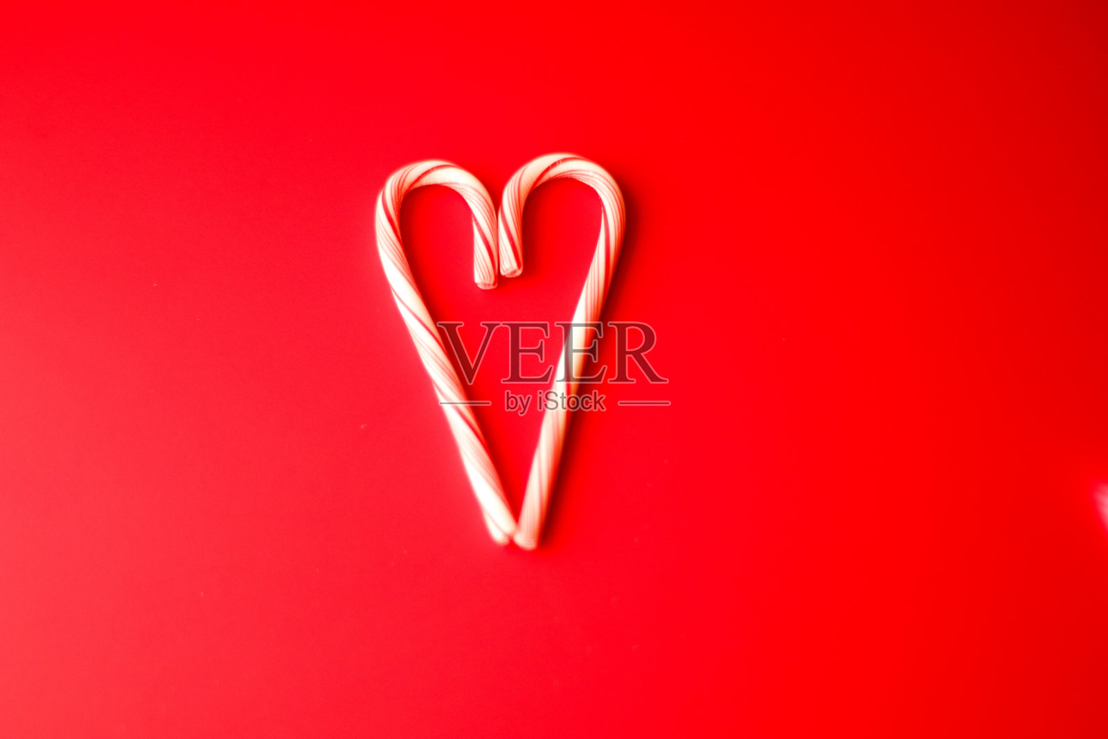 薄荷糖拐杖红色背景圣诞节或情人节。照片摄影图片