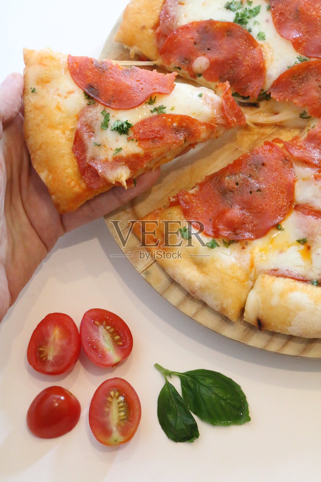 手拿一块披萨照片摄影图片