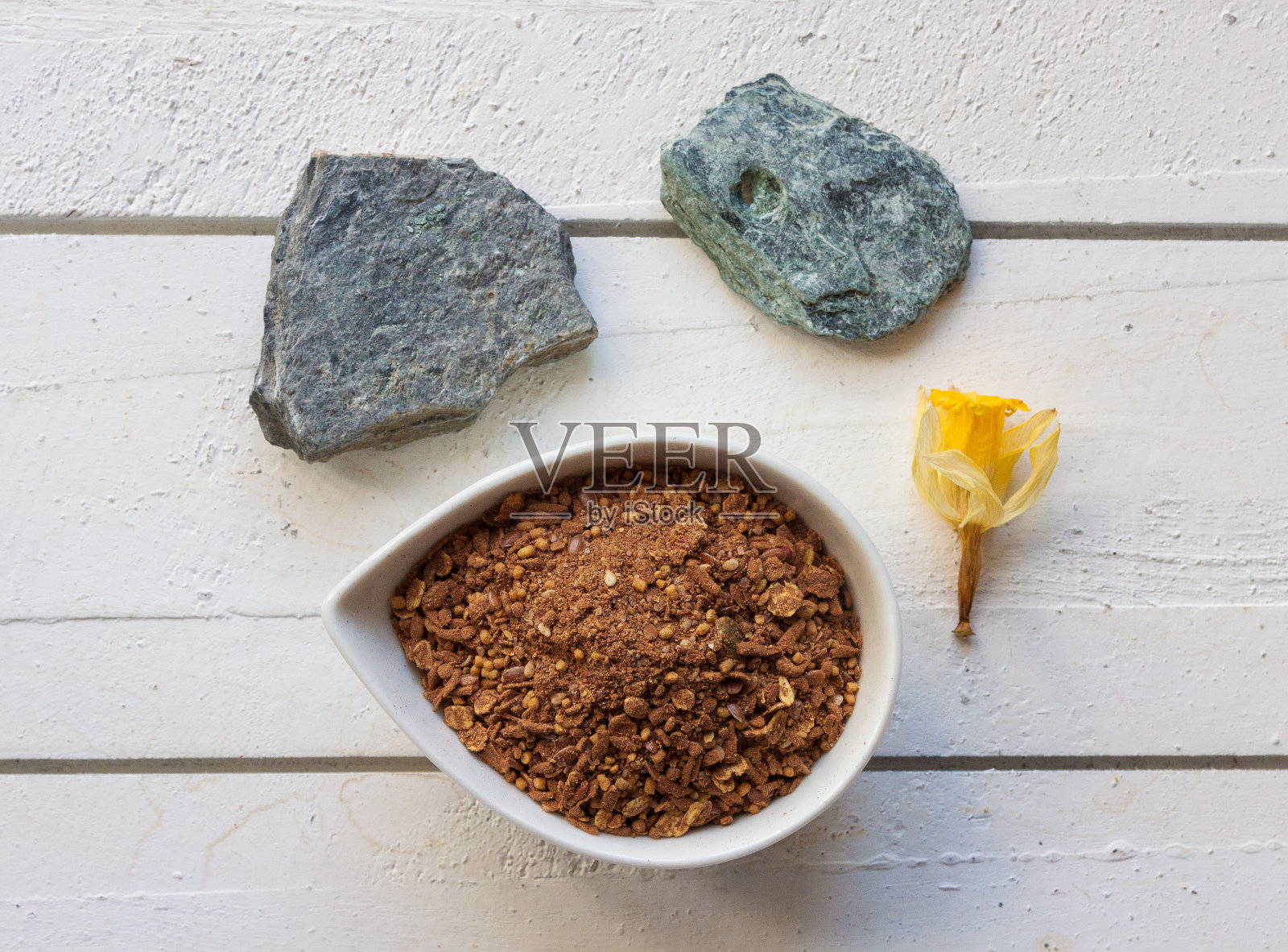 一杯麦片麦片在一个白色的木制顶部与石头和花卉装饰设置照片摄影图片