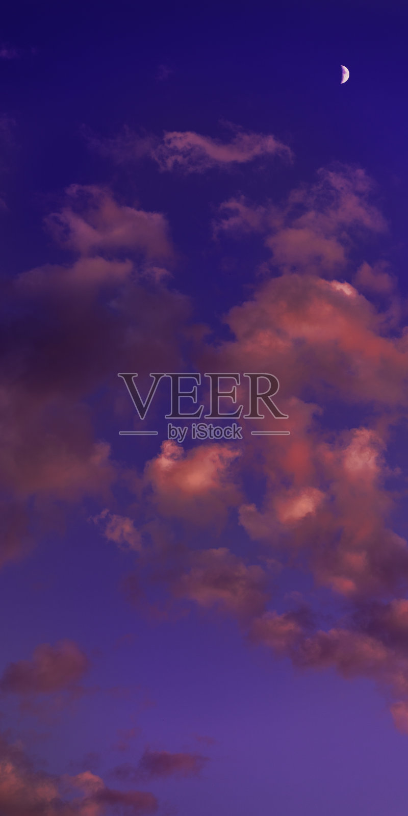 蓝色的天空，月亮和白色的粉红色的云。日落。照片摄影图片