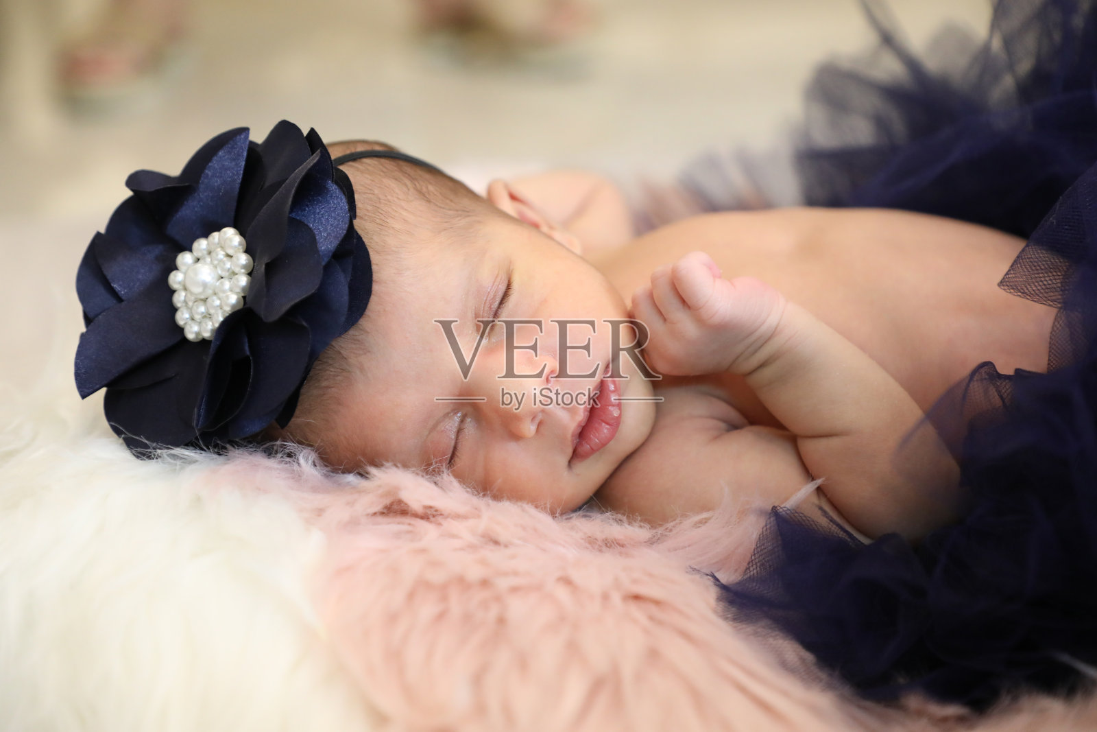 穿着蓝色连衣裙的可爱女孩在柔软的羊毛上睡觉照片摄影图片