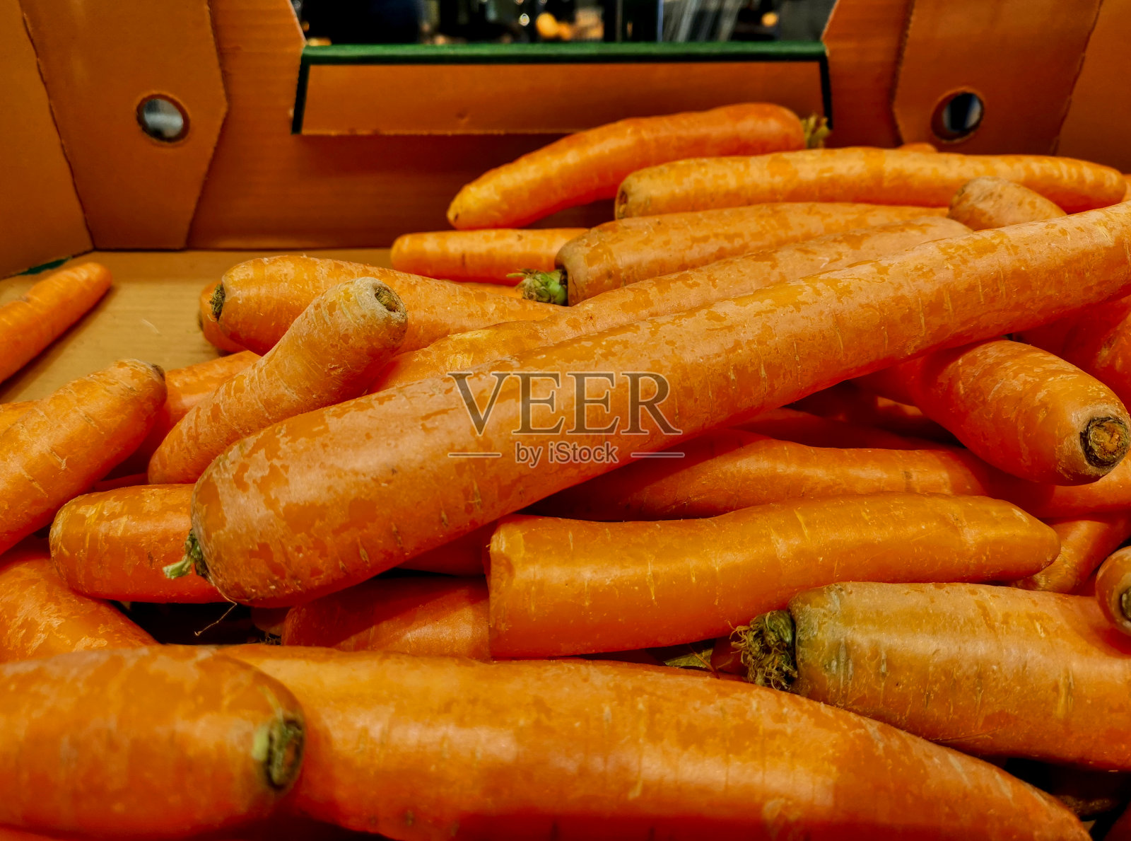 在商店里展示的硬纸板箱里的新鲜胡萝卜照片摄影图片