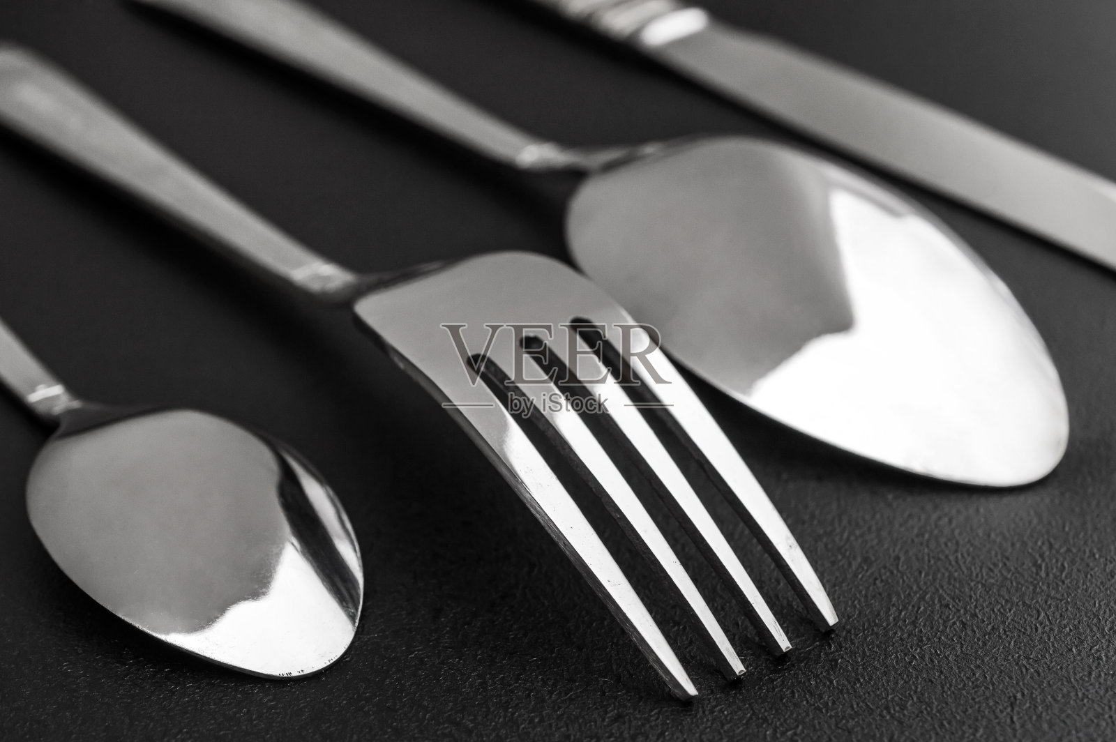 叉子、刀和勺子放在黑色背景上。关闭了。照片摄影图片