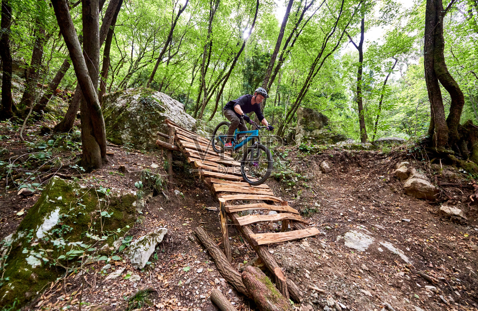 在树林中，骑自行车的人在自建的小径上挑战下降照片摄影图片