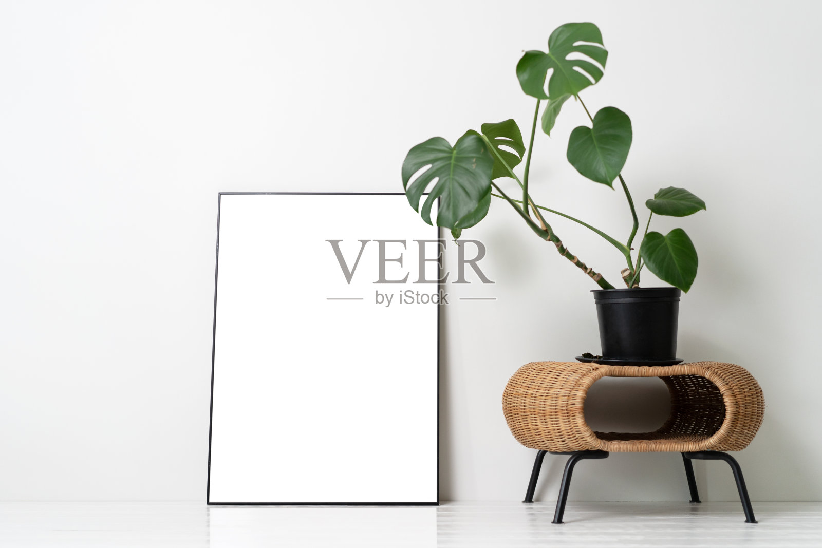 白色墙壁上的空白画布框架模型。View of modern scandinavian style interior with artwork mock up on wall照片摄影图片