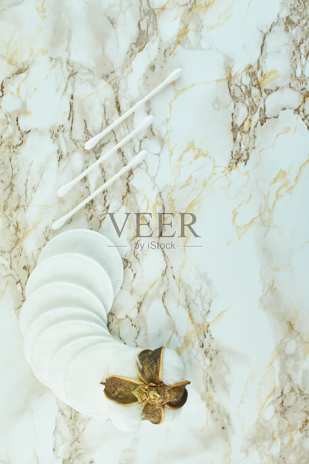 棉花花与软化妆垫大理石纹理背景。照片摄影图片