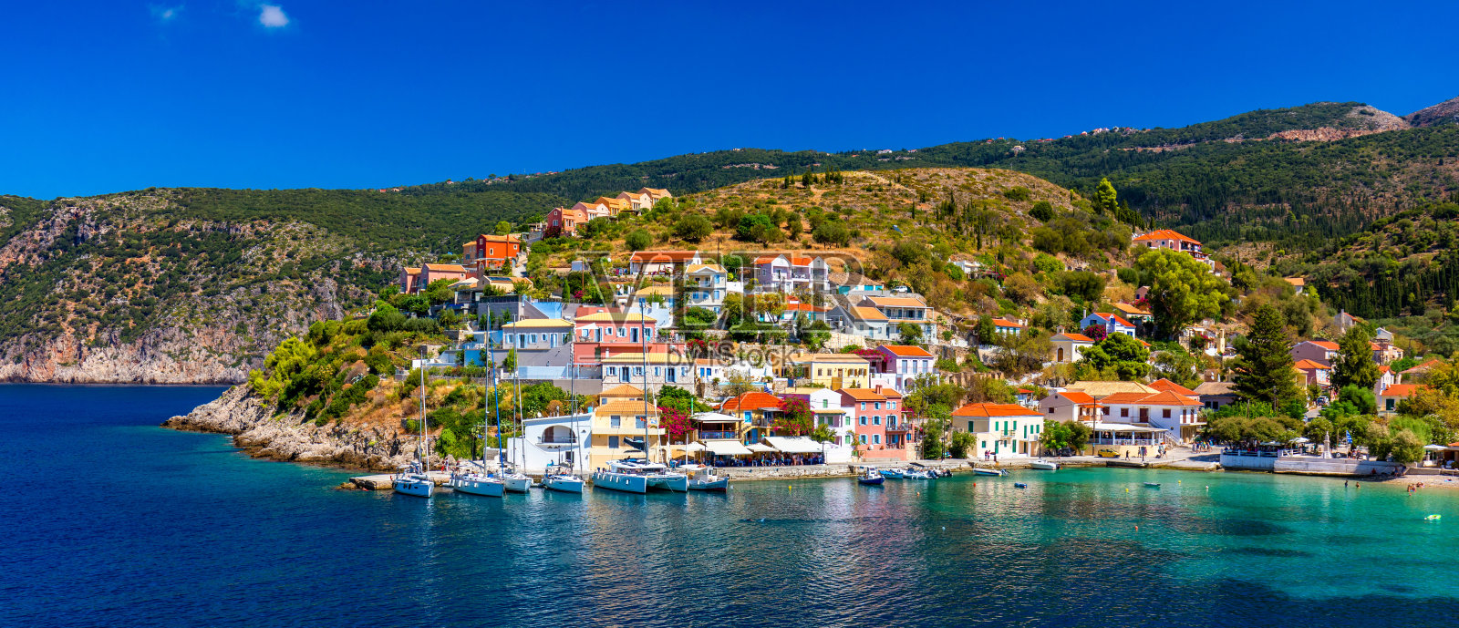 希腊凯法利尼亚的阿索斯村。地中海绿松石色的海湾与美丽多彩的房屋在阿索斯村在Kefalonia，希腊，爱奥尼亚岛，塞弗尼亚，阿索斯村。照片摄影图片