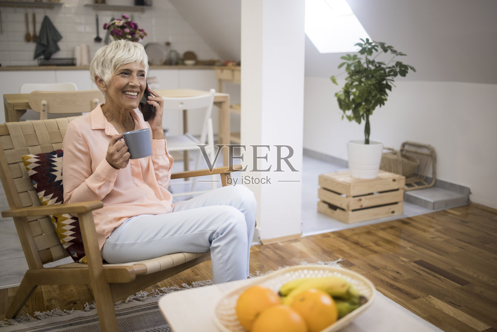 一个拿着咖啡杯打电话的老妇人照片摄影图片