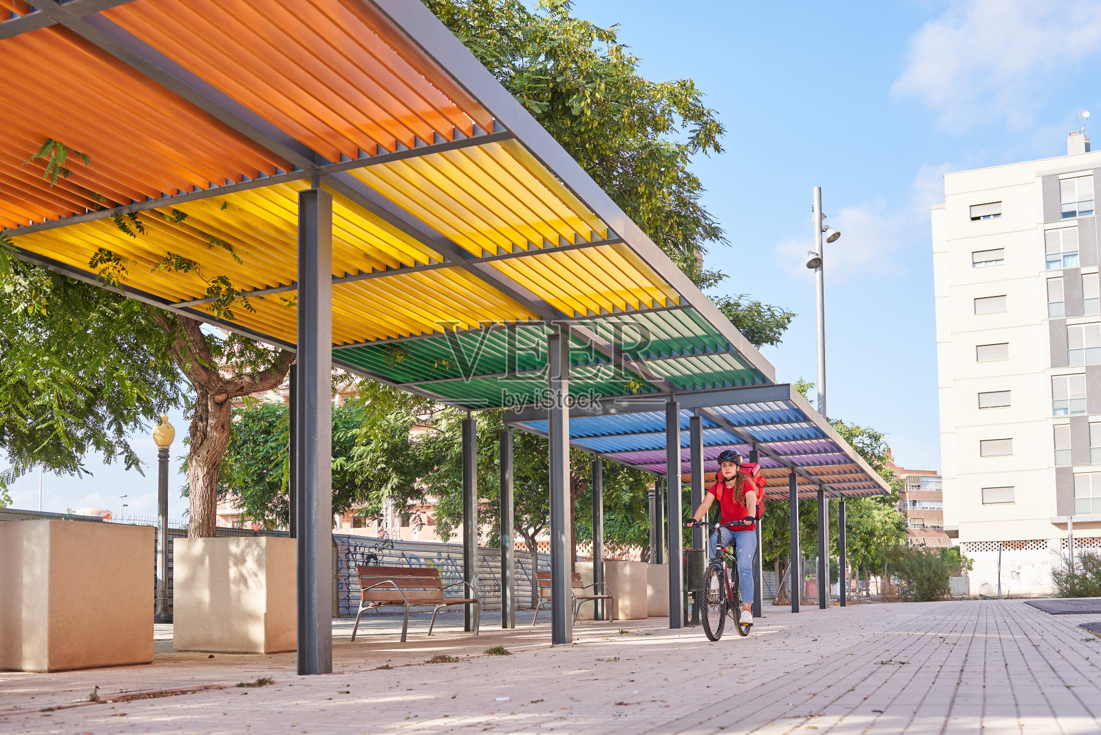 一个送货女孩骑着她的自行车在一个彩色的背景照片摄影图片