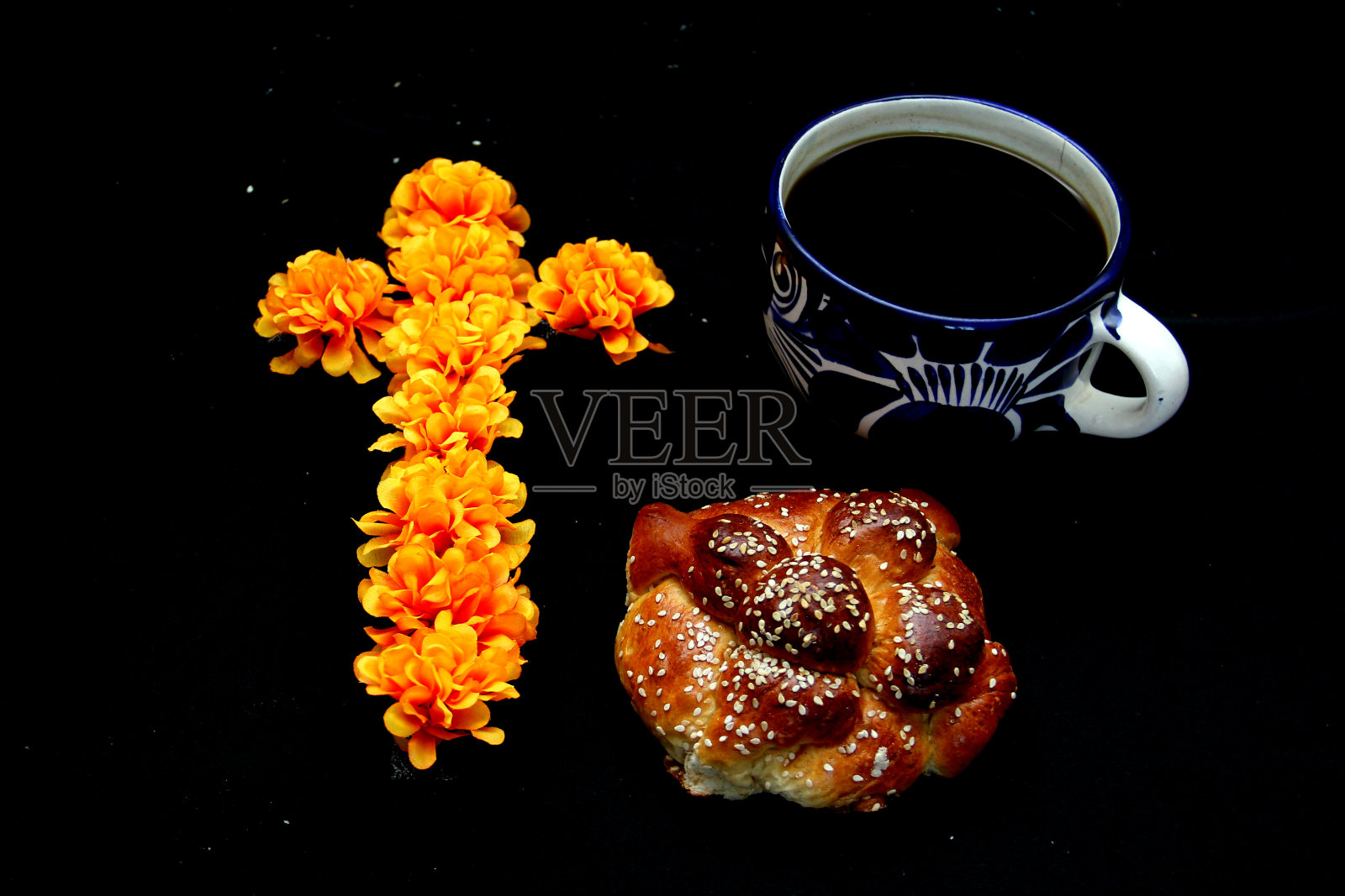 工匠杯里的热咖啡，松软美味的死者面包，加上芝麻，以香槟酒、彩色剪纸和蜡烛装饰，为亡灵节提供祭品照片摄影图片