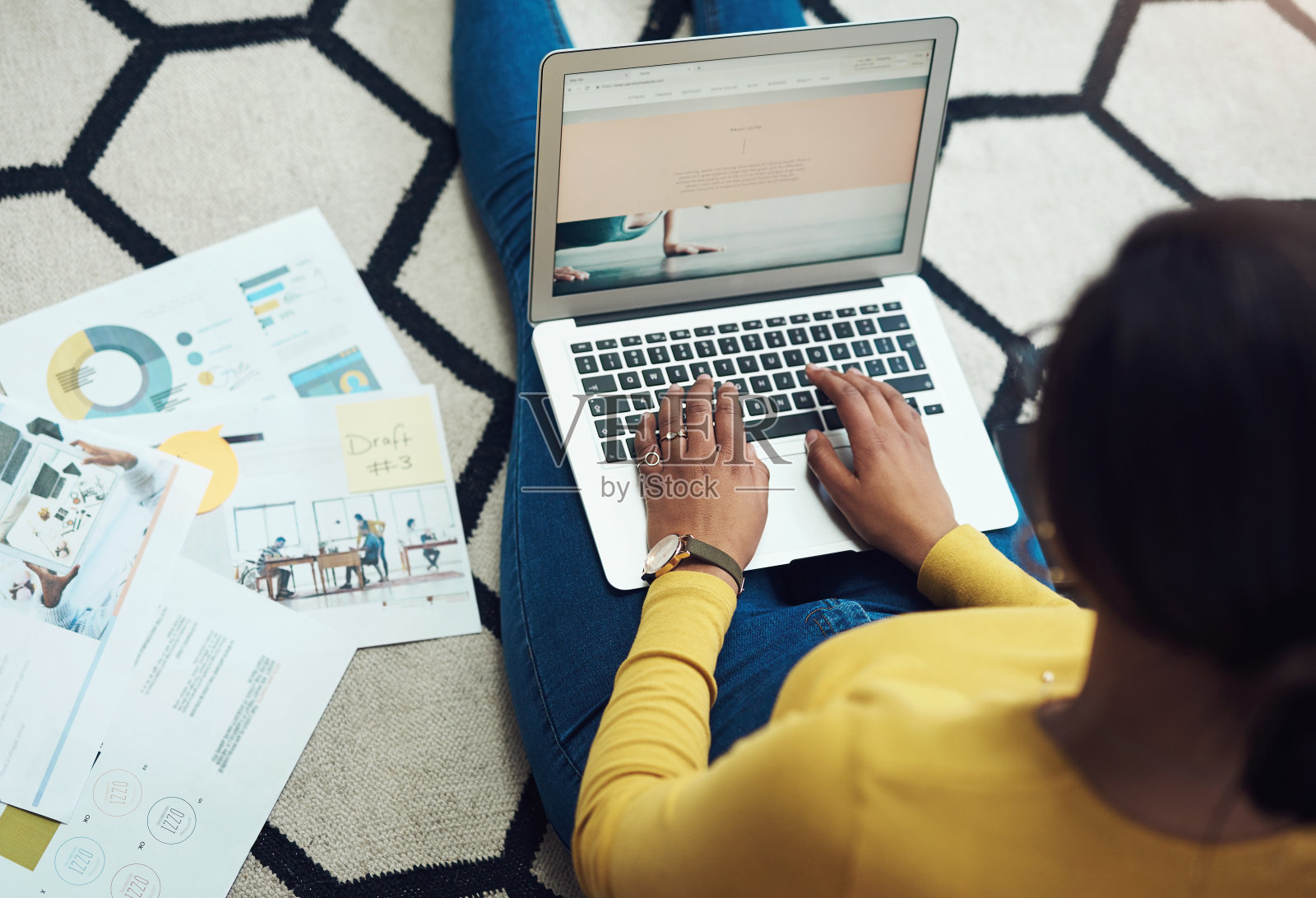 高角度拍摄了一个不知名的女人独自坐在家里，使用她的笔记本电脑照片摄影图片