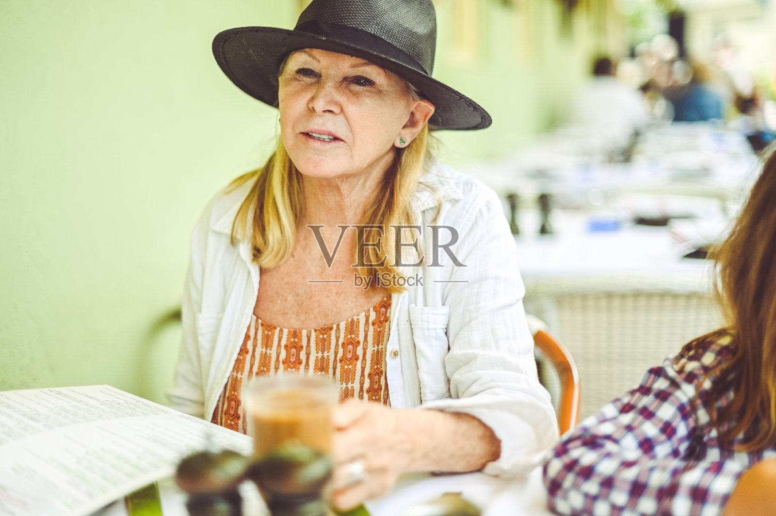 一位老年妇女和家人在户外餐厅喝着高档咖啡照片摄影图片