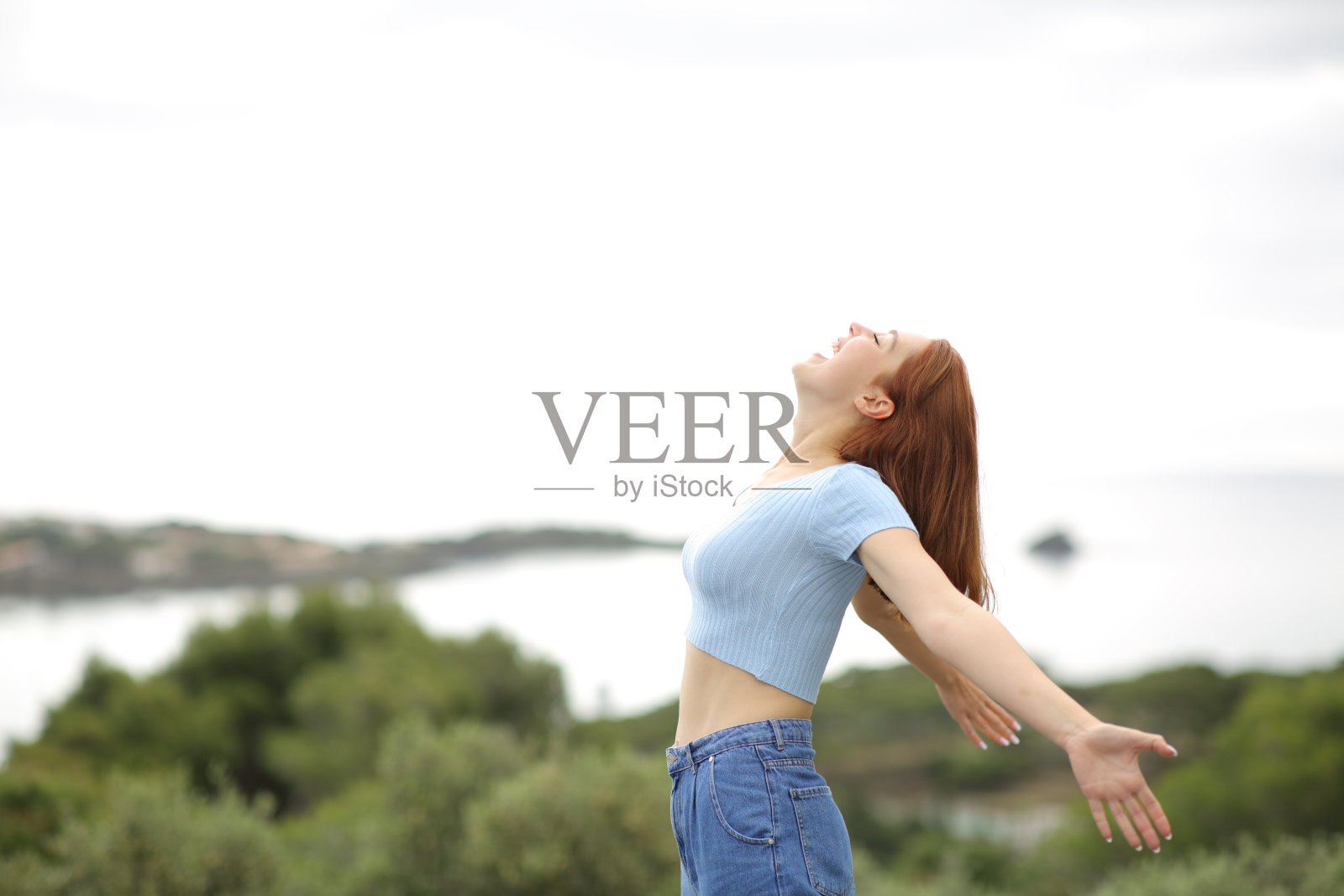 快乐的女人在海边对着空气尖叫照片摄影图片