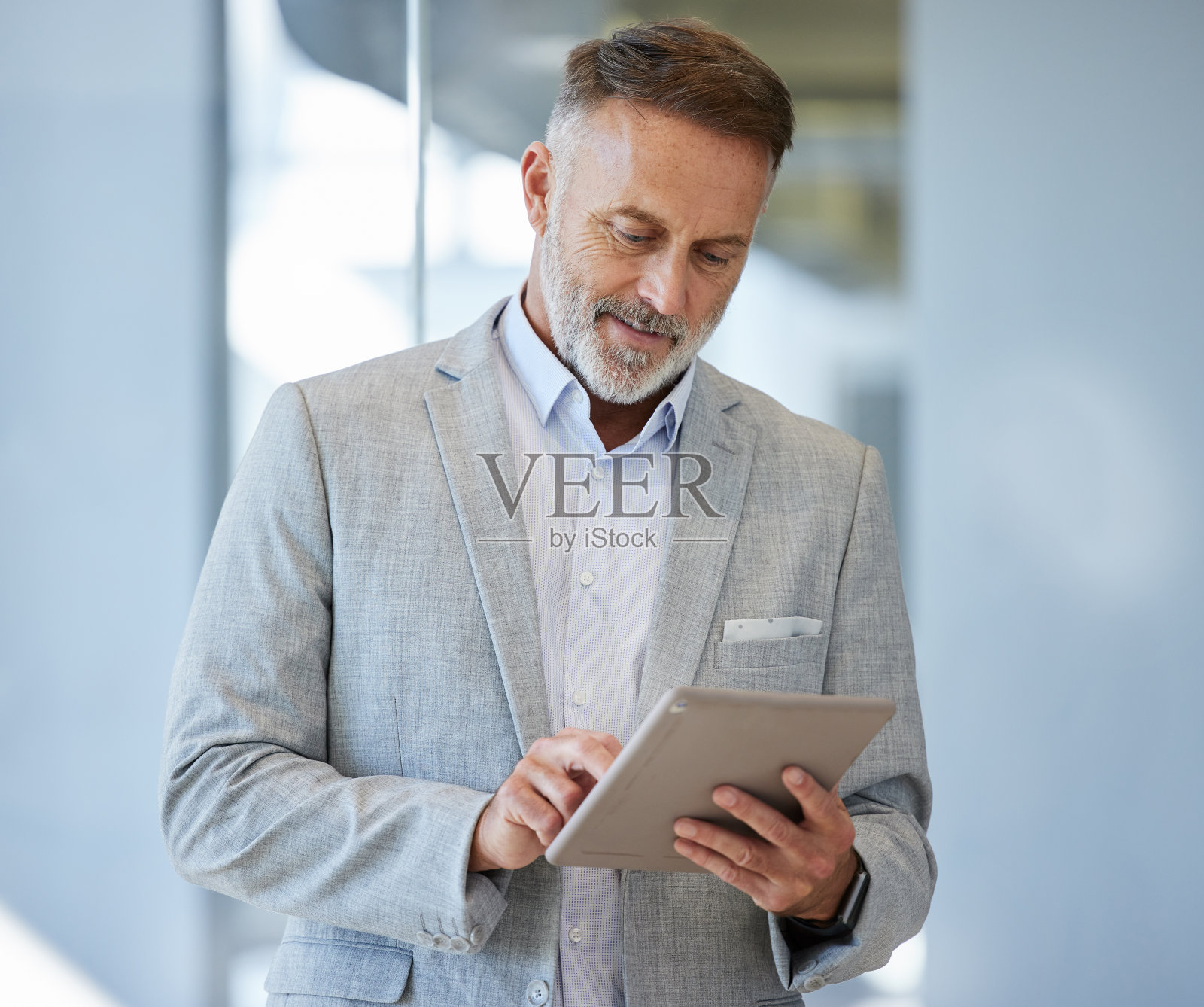 一位成熟的商人在办公室里使用数字平板电脑照片摄影图片