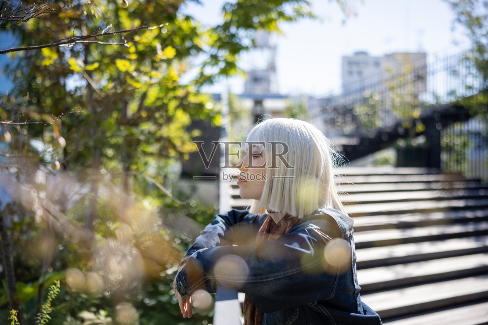 戴着铂金假发的年轻女子在城市里放松照片摄影图片