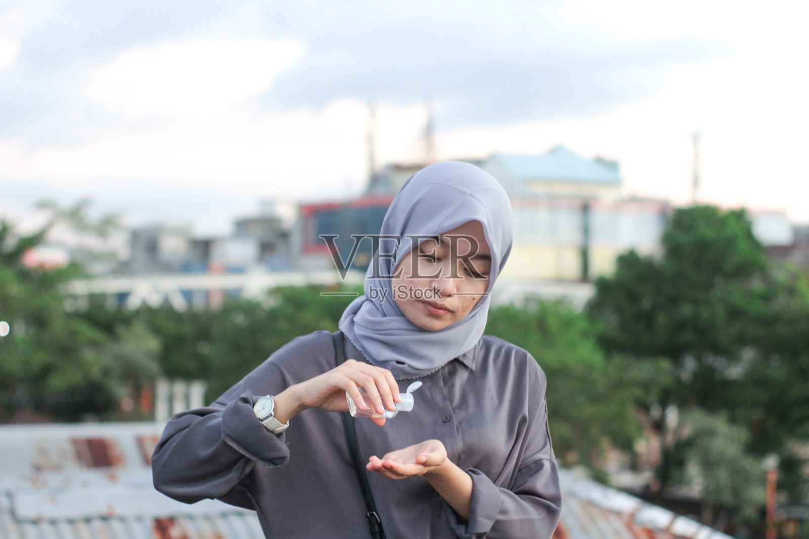 年轻女性在屋顶城市公园使用洗手液照片摄影图片