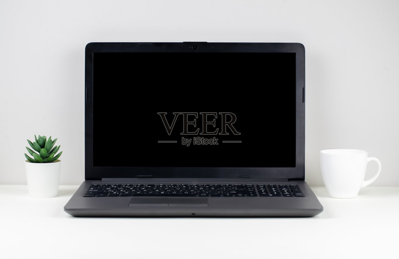 笔记本电脑，一杯咖啡和家庭植物在白色的桌子上照片摄影图片