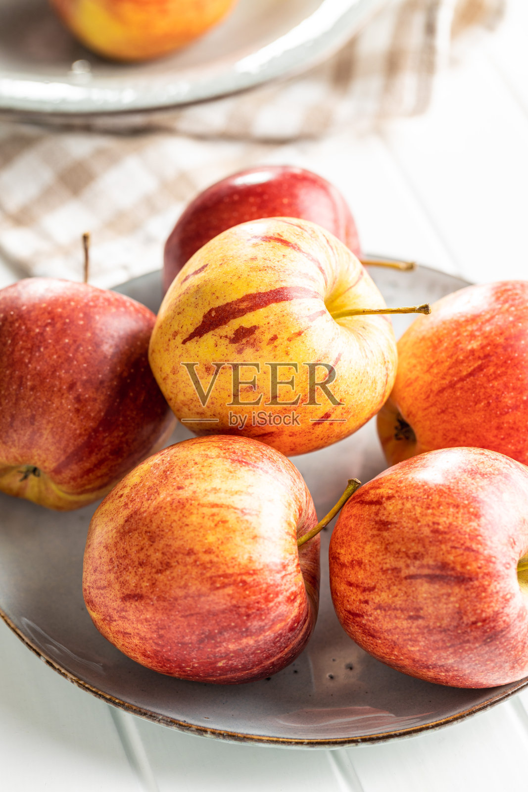 盘子里有新鲜的秋苹果。照片摄影图片