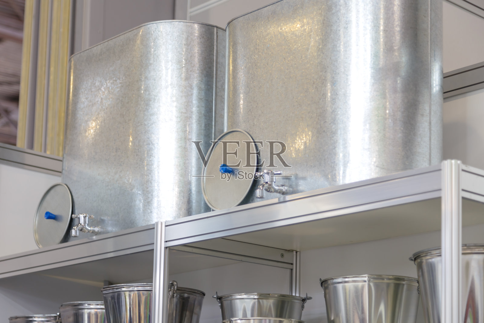 销售镀锌各种家居用品及产品。铁桶，水箱，水槽，盥洗架在商店的架子上。金属工业、园林设备制造照片摄影图片