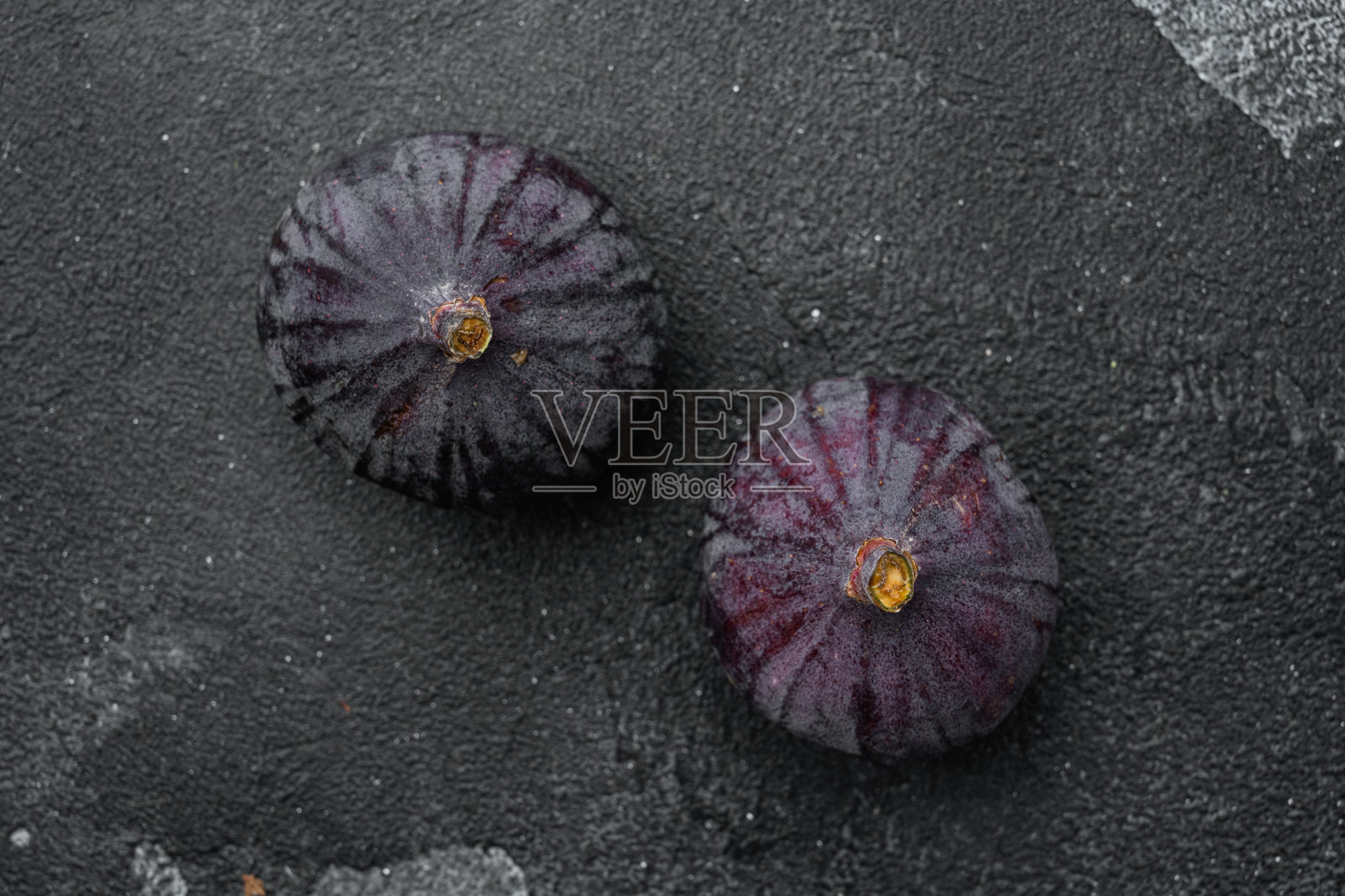 香甜成熟的无花果果实，在黑色的深色石质桌子背景上，顶视图平铺，带有文本复制空间照片摄影图片