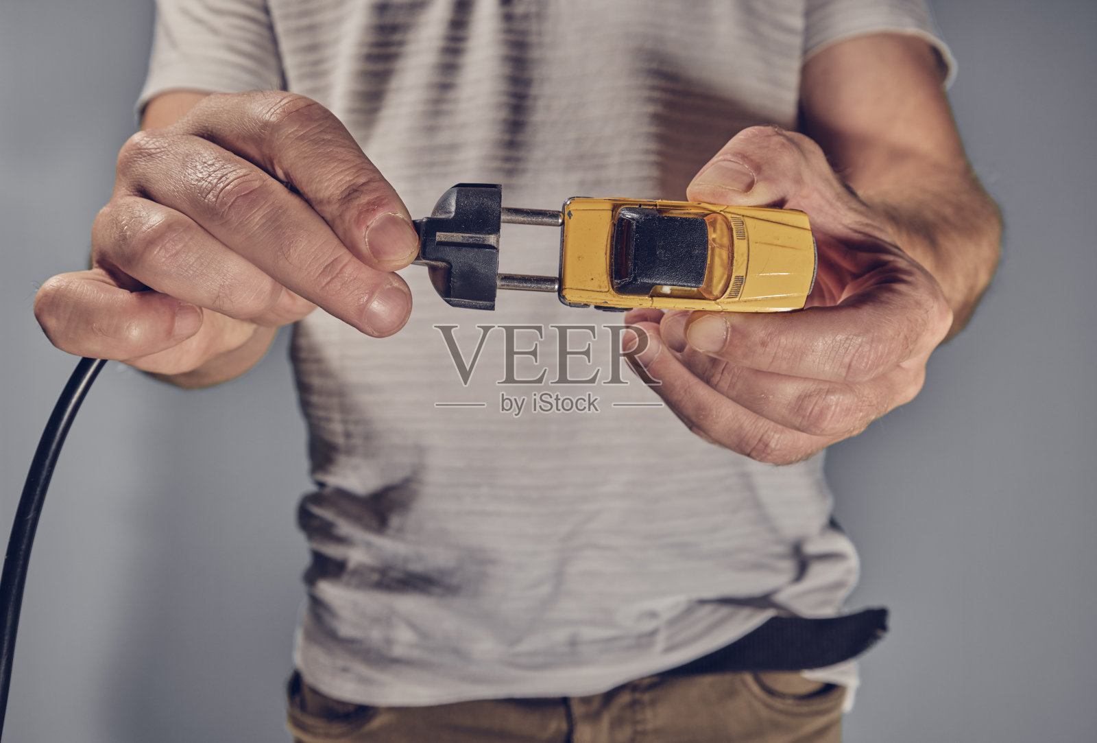 带着玩具车和电源插头的男人照片摄影图片