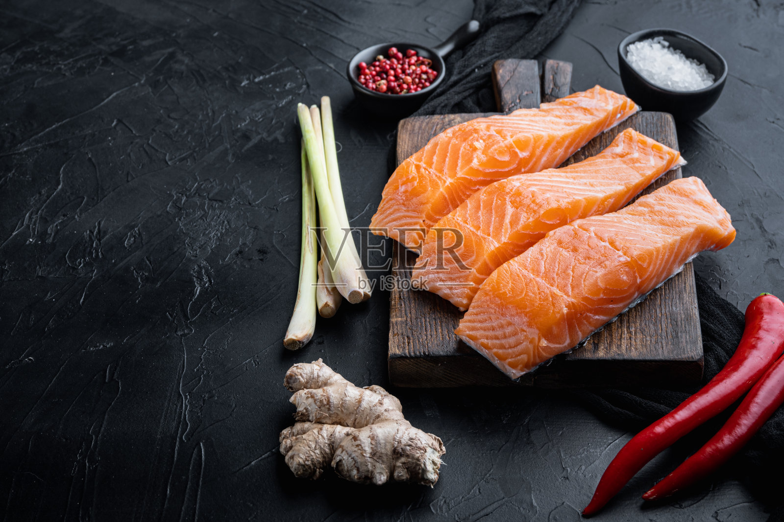 鱼肉饼原料与三文鱼和柠檬草，黑色纹理背景照片摄影图片
