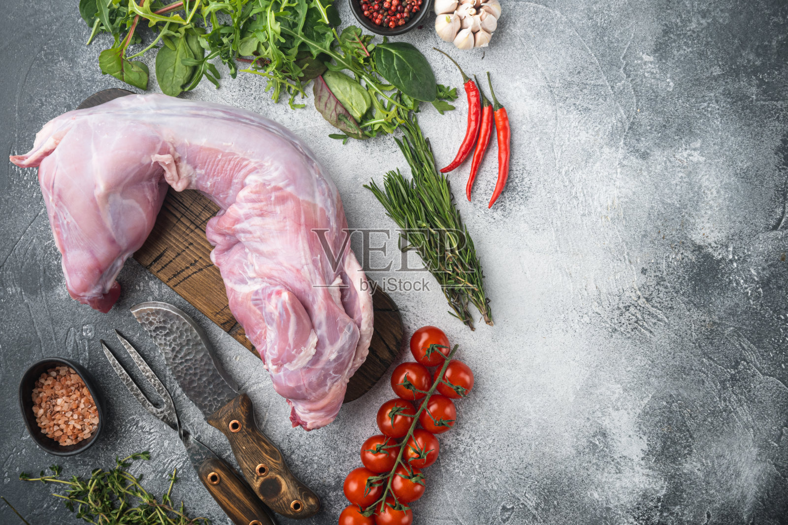 生兔肉配上新鲜的蔬菜、香草和香料，在灰色的石头背景上，顶视图平铺，带有文本的复制空间照片摄影图片