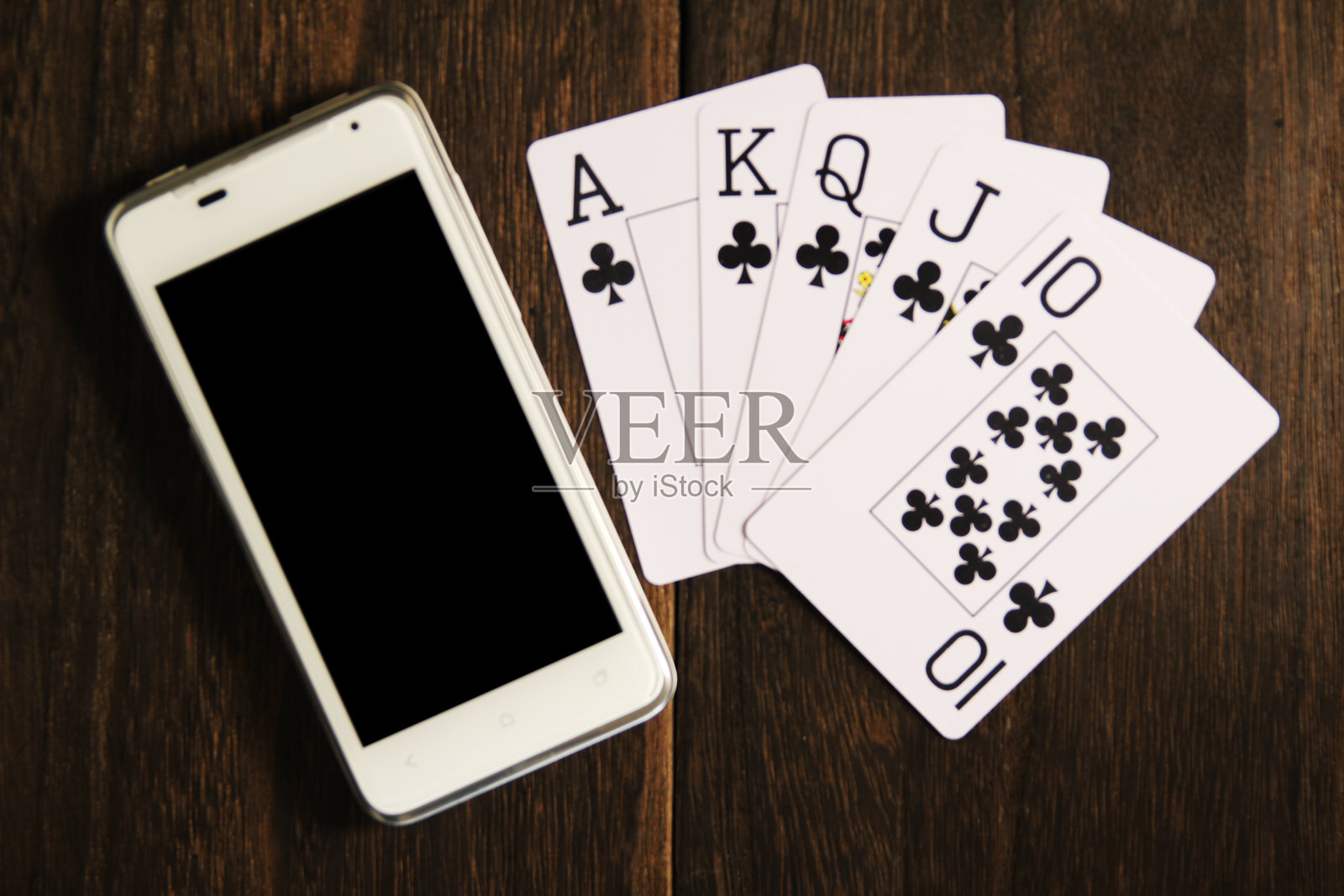 在木桌上玩纸牌和智能手机照片摄影图片