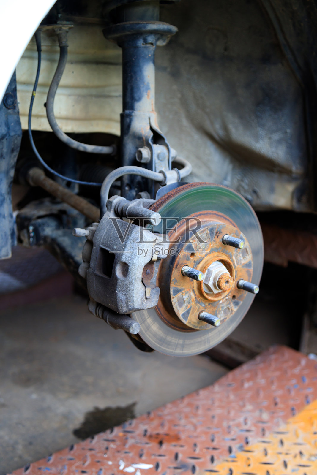 将汽车的轮毂拆下，对车轮进行制动和轮胎保养，用汽车千斤顶吊起汽车进行维修照片摄影图片