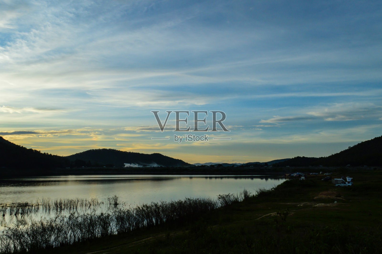 美丽的日落在湖和山。照片摄影图片