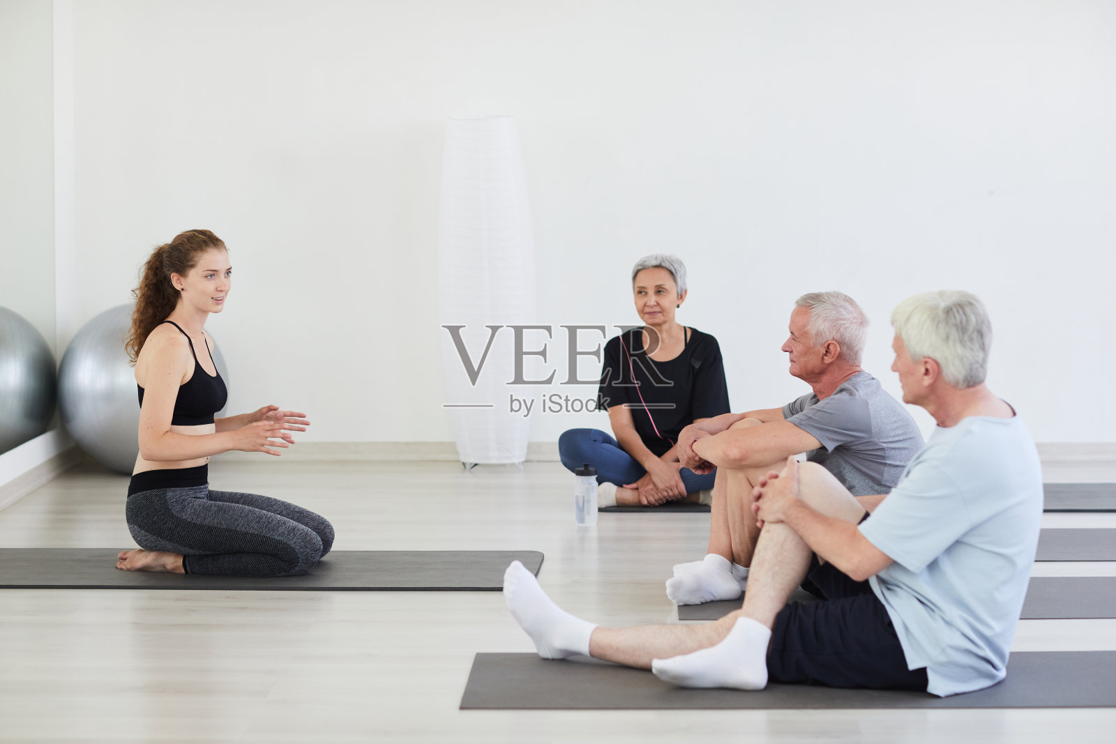 和教练一起坐在健身房里的老人照片摄影图片