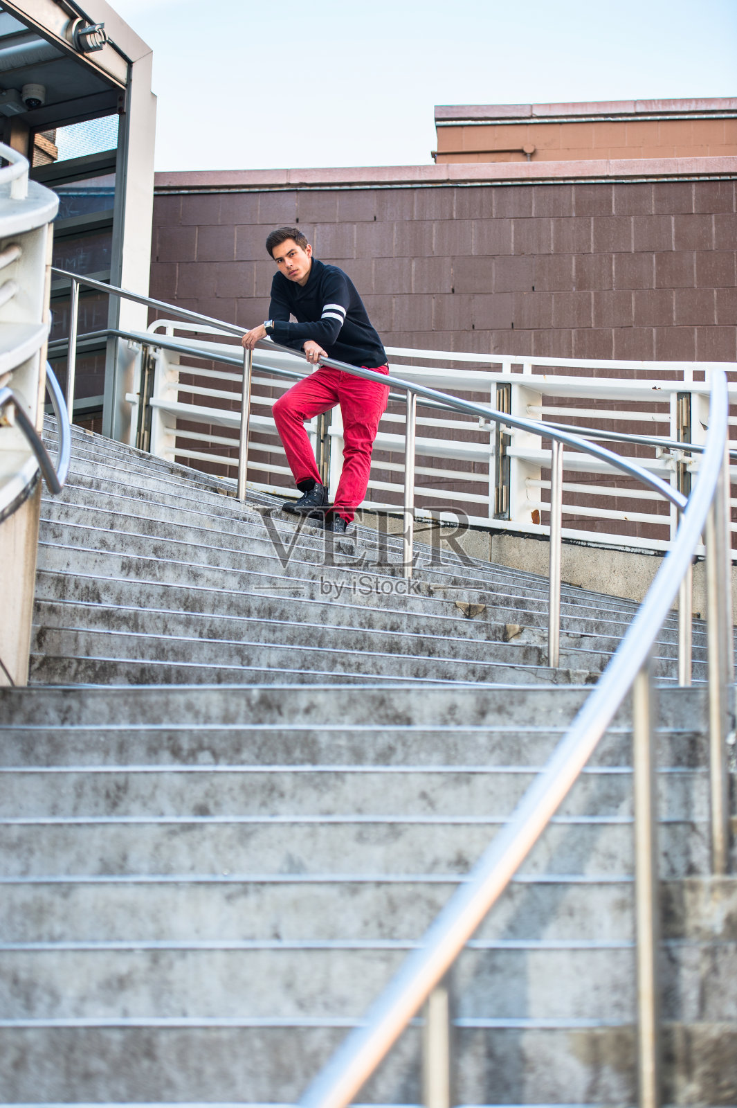 一个年轻人站在纽约市户外的楼梯上放松照片摄影图片