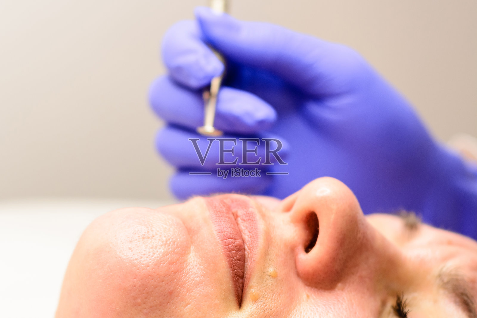 美容师用勺子清洁病人的皮肤，保湿，清洁和皮肤护理。照片摄影图片