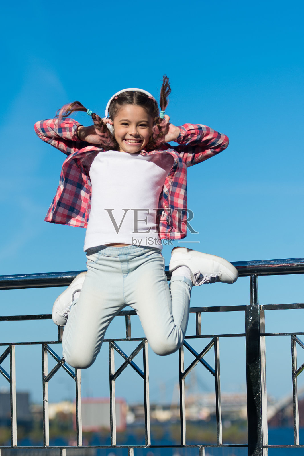 音乐带走了我。快乐的小女孩。小音乐迷。小女孩在户外听音乐。快乐的孩子戴着耳机。自由是幸福照片摄影图片