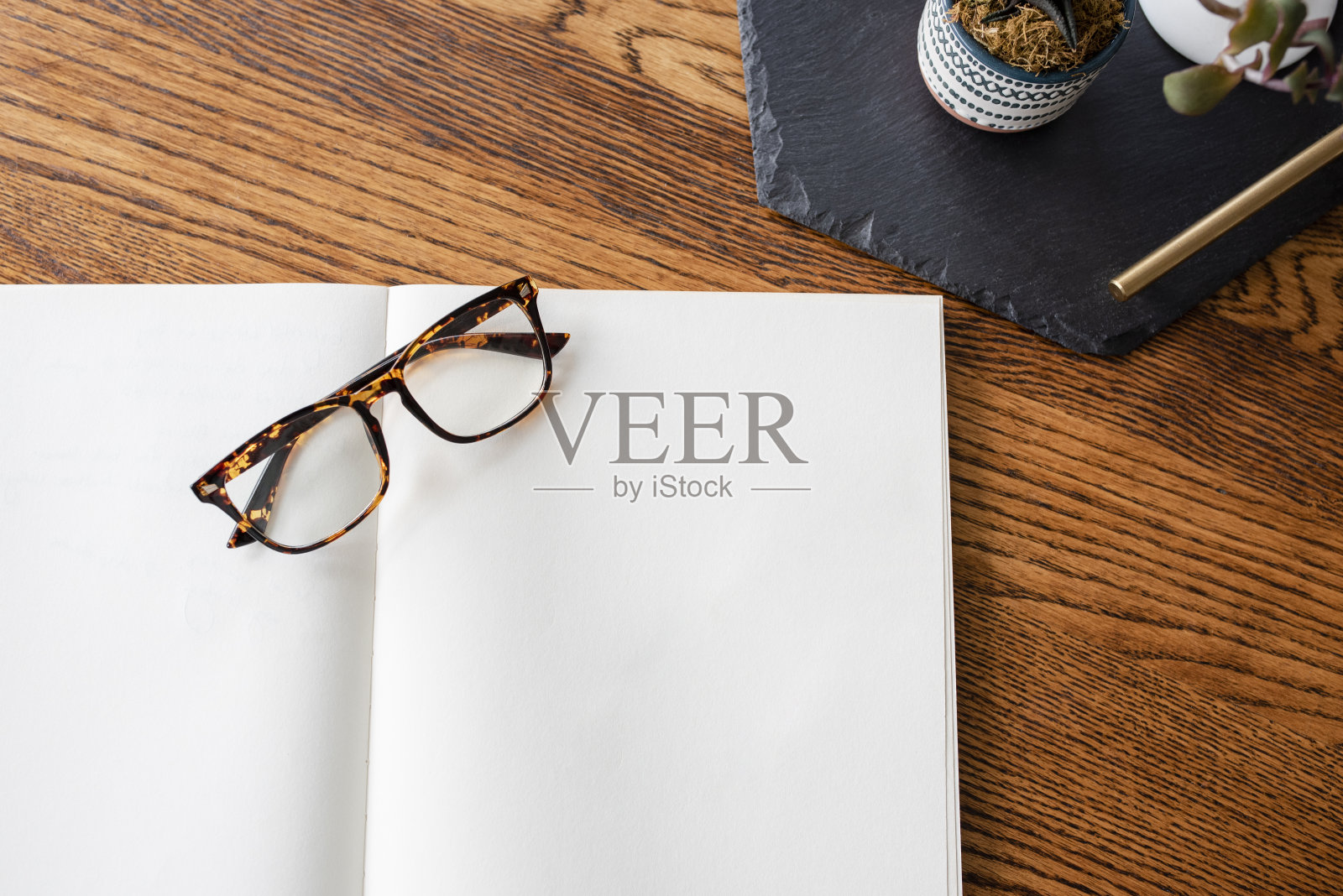 暖木头上的眼镜和空白笔记本照片摄影图片