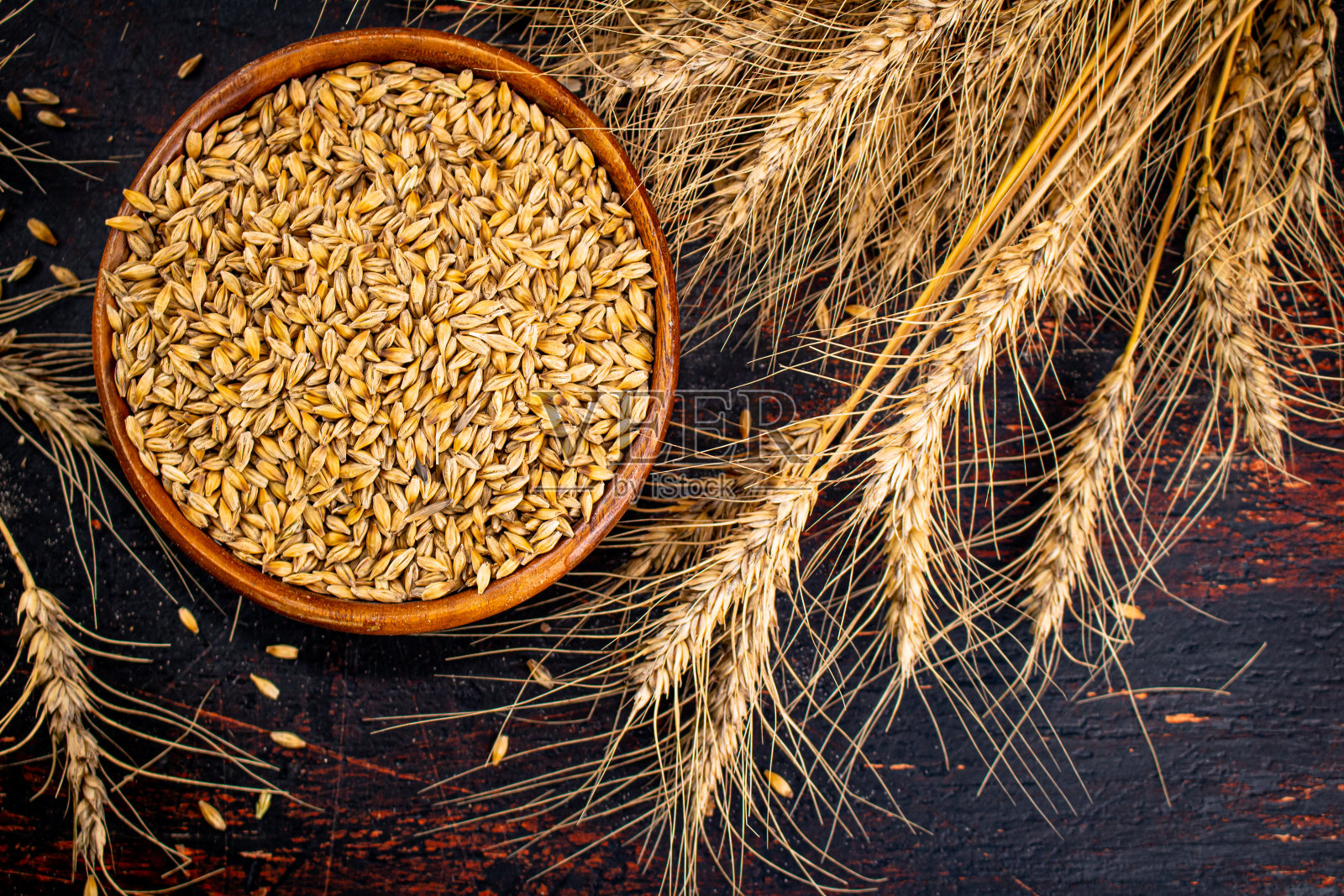 装有大麦粒的木制盘子。前视图。照片摄影图片